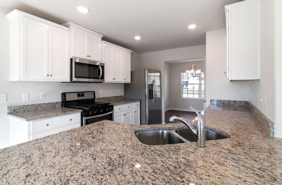 Countertop Replacement, sleek kitchen interior featuring granite countertops and stainless steel appliances
